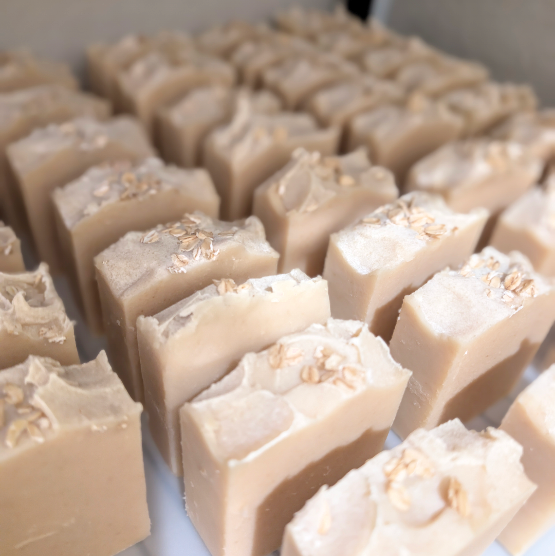 Beige soap bars with visible ingredients on a white surface