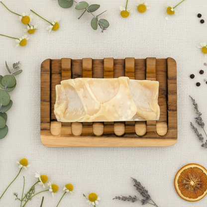 Bar of soap on a wooden soap dish with a white background