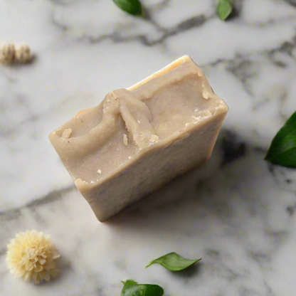 Bar of soap on a marble surface with small flowers and leaves