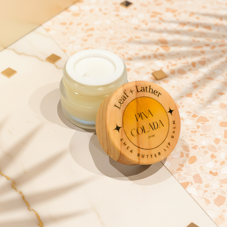 Shea butter lip balm with wooden lid on a white surface