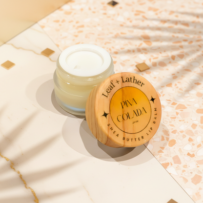 Shea butter lip balm with wooden lid on a white surface