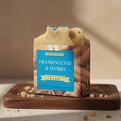 Shea butter soap bar with Frankincense & Myrrh scent on a wooden board against a beige background