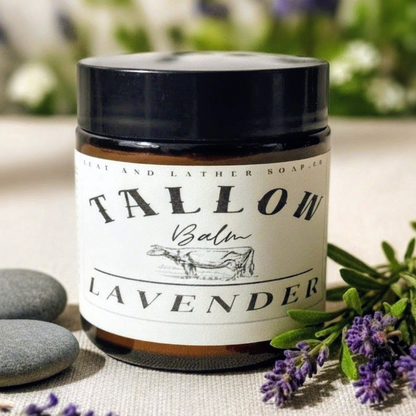 Jar of Talloh Balm Lavender on a surface with lavender flowers and stones in the background.