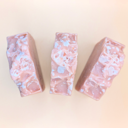 Three pink and white marbled soap bars on a light beige background