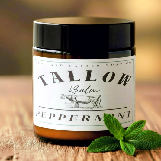 Jar of Tallow Balm with peppermint leaves on a wooden surface