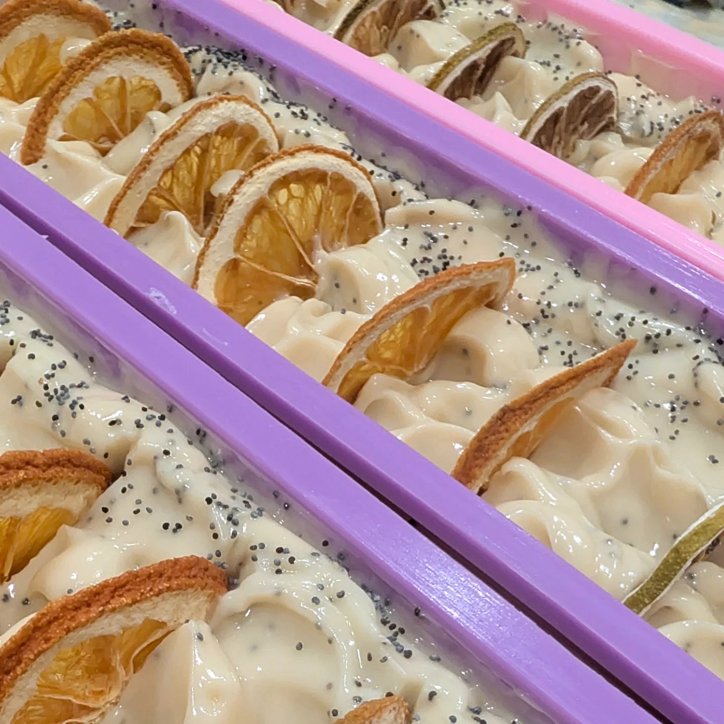 soap  with orange slices and poppy seeds in a container.